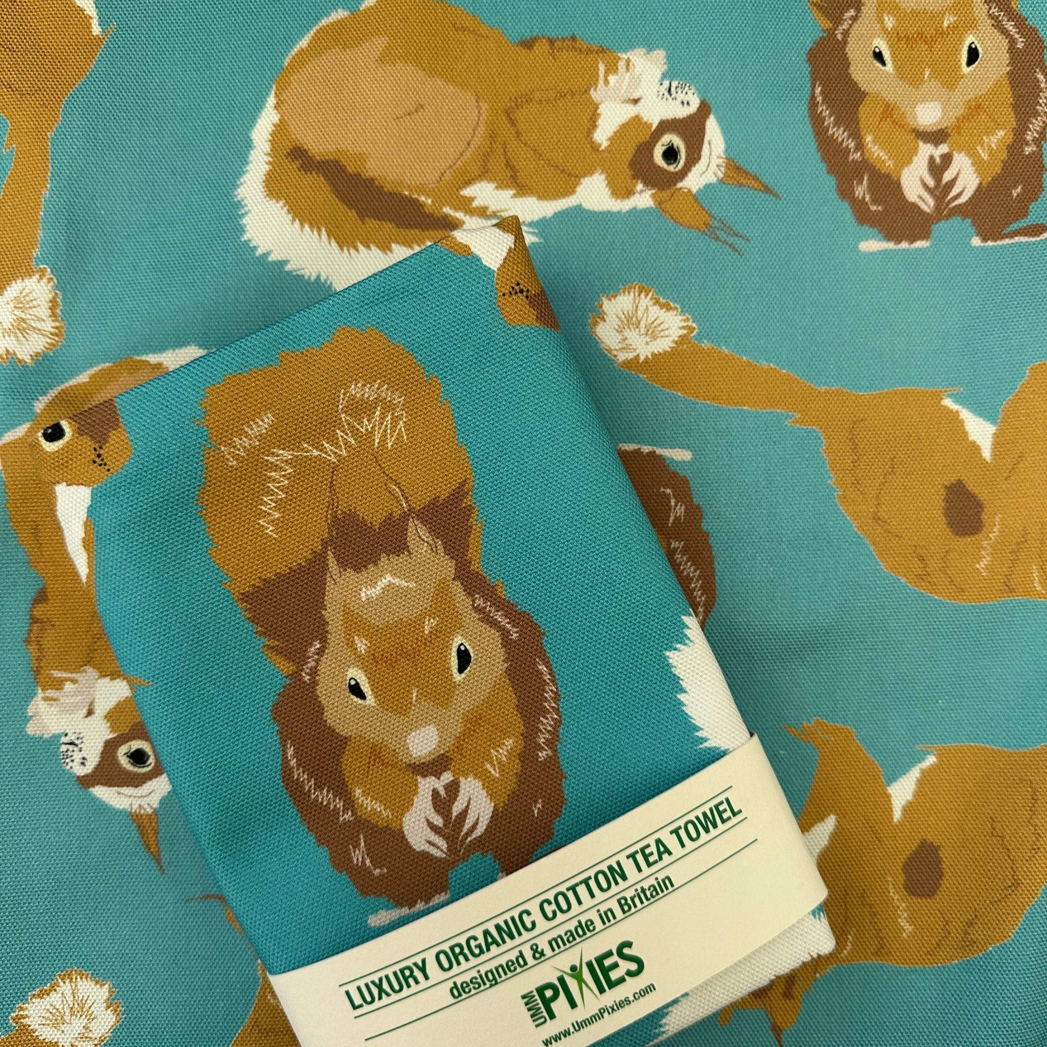 Red Squirrel design teal cotton tea towel shown in packaging
